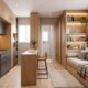 Apartamento pequeno com cozinha, bancada e sala integradas, móveis planejados em madeira e cinza