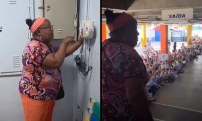 Mulher de óculos na escola, à esquerda manipulando aparelho, à direita diante de alunos sentados no chão