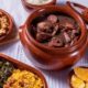 Feijoada completa com feijão preto, carnes, torresmo, arroz, couve, farofa, vinagrete e laranja