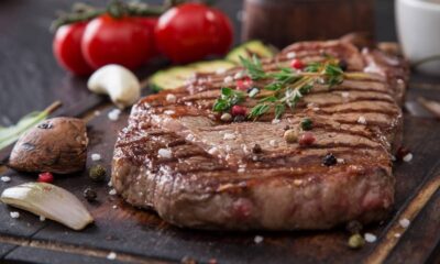 Bife grelhado em tábua de madeira com sal, pimenta, tomilho, tomate, cogumelos e alho no fundo