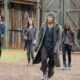 Seis personagens de The Walking Dead, incluindo Rick, Michonne e Daryl, caminham armados em um acampamento