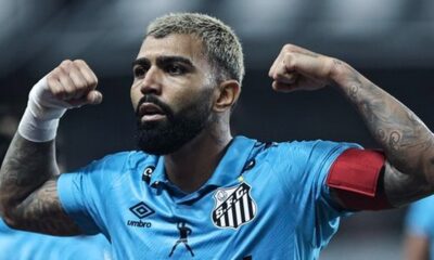 Gabriel Barbosa, camisa azul do Santos, barba e cabelo loiro, flexionando os braços