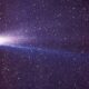 Cometa brilhante com cauda longa e luminosa em um céu noturno estrelado