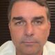 Close-up do senador Flávio Bolsonaro, com expressão neutra, olhando diretamente para frente