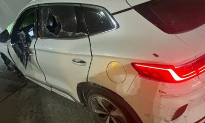 SUV branco com vidros laterais quebrados, amassados e marcas de tiros na lataria do veículo