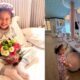 Mavie sorrindo com tiara "Birthday Girl", buquê de flores e em festa de pijama decorada