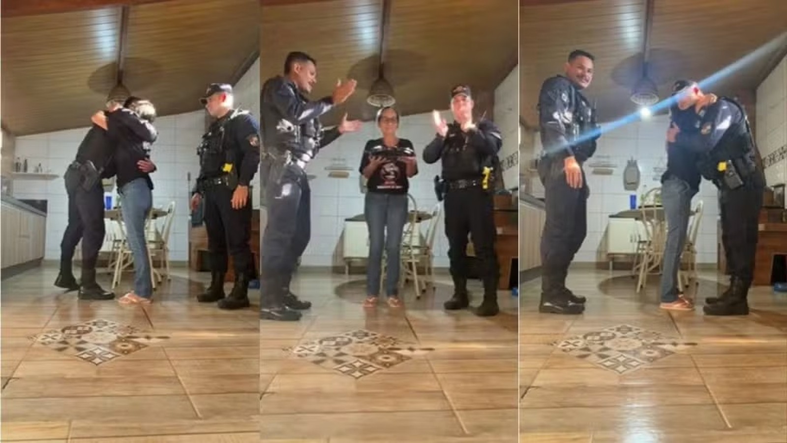 Policiais fardados comemoram aniversário com mulher em casa, com abraços, palmas e bolo