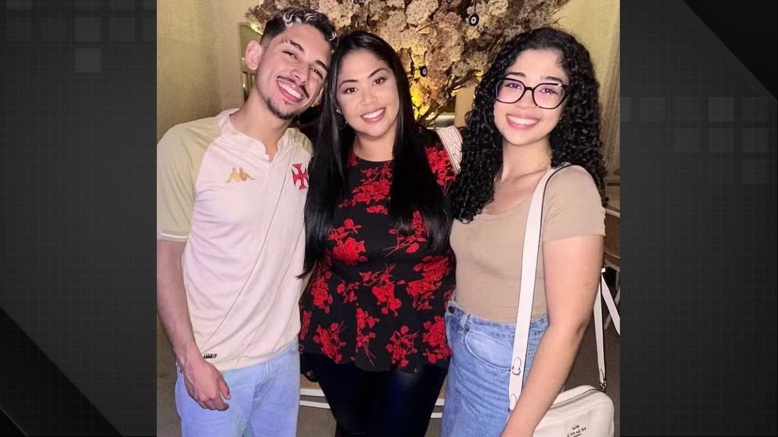 Três pessoas sorrindo: um jovem de barba, uma mulher de blusa floral e uma jovem de óculos