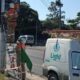 Dois eletricistas da Light em escadas consertam fiação em poste com van de serviço
