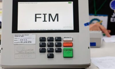 Urna eletrônica exibe "FIM" na tela, teclado numérico e botões Branco, Corrige, Confirma.