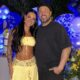 Casal sorridente Rayane Figliuzzi e Belo em festa com balões azuis e flores amarelas