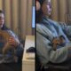 Mulher com fones trabalha no computador, cachorro pequeno no casaco canguru, mesa e monitor