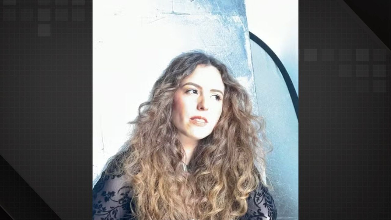 Retrato de Renata Alves Mietto, mulher com cabelo cacheado olhando para o lado direito