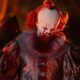 Pennywise, o palhaço de IT, com maquiagem sangrenta e um cutelo de açougueiro na mão