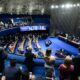 Vista aérea do plenário do Senado Federal, com diversos senadores em sessão de votação