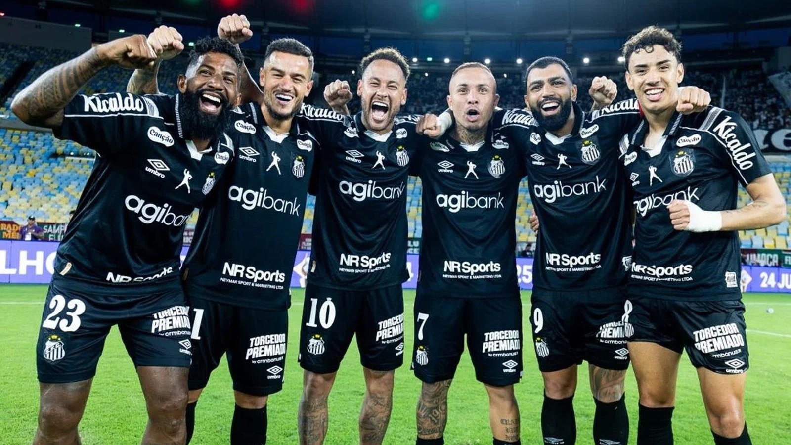 Seis jogadores do Santos sorriem e celebram em campo, vestindo uniformes pretos