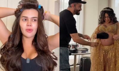 Franciny Ehlke de bobes no cabelo e grávida com maquiador aplicando produto na barriga