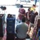 Interior de bar ou comércio de bebidas com pessoas, garrafas e caixas empilhadas
