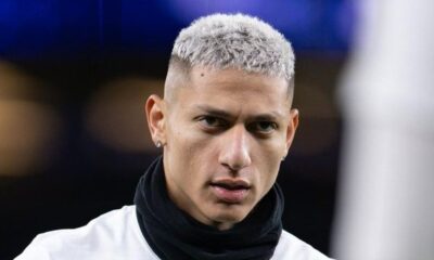 Rosto do jogador Richarlison, cabelo platinado, usando brincos e gola preta