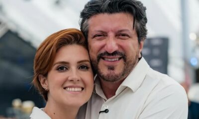 Mila Seidl e Lito Sousa sorrindo, abraçados, olhando para a câmera.