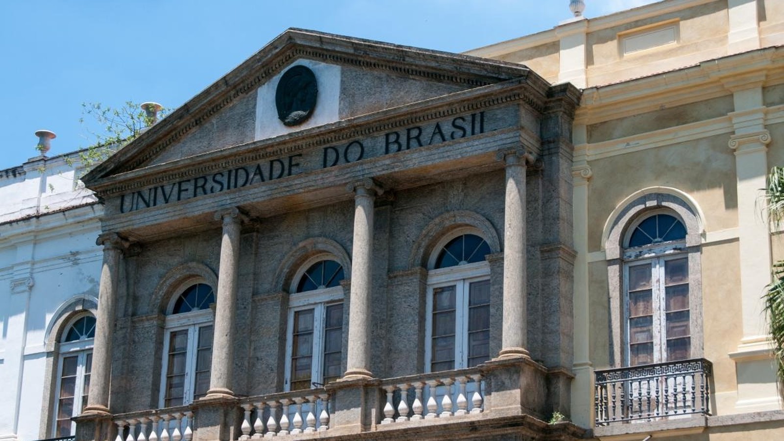 Fachada de prédio universitário de pedra com colunas e inscrição "UNIVERSIDADE DO BRASIL"