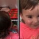 Criança na geladeira comendo doce e depois sorrindo com boca suja de chocolate