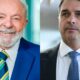 Lula sorridente de terno azul e Flávio Bolsonaro sério de terno escuro, lado a lado
