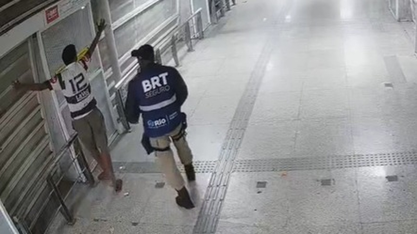 Agente do BRT Seguro com colete detém homem de camisa 12 e braços erguidos em estação