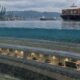 Renderização de um túnel imerso para veículos abaixo da água, com navios e um porto acima