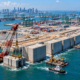 227 blocos de concreto gigantes estão sendo colocados no mar para construir um muro de 9,1 km em Singapura, que vai sustentar o maior porto automatizado do mundo
