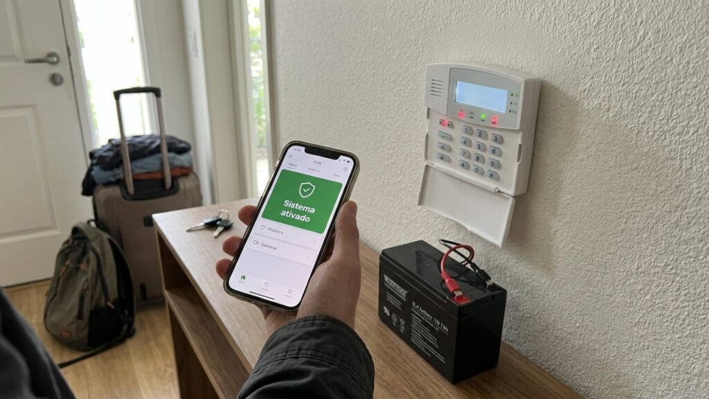 Dono de casa instala um sistema de alarme com sensores nas portas e janelas para evitar furtos durante viagens e descobre como a manutenção das baterias, os testes periódicos e a conexão com a central interferem no funcionamento do equipamento