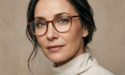 Mulher madura usando óculos de grau com armação marrom e maquiagem natural nos olhos, com sombra esfumada, sobrancelhas definidas e cílios delicados. - Imagem ilustrativa criada por inteligência artificial