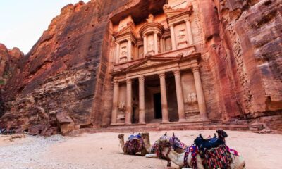 Fachada de Al-Khazneh em Petra, Jordânia, com três camelos coloridos no deserto