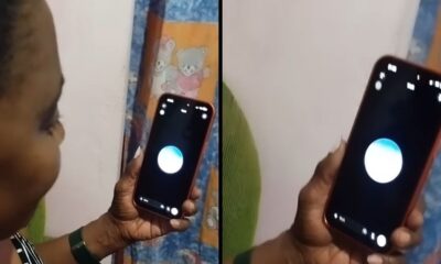 Mulher segura smartphone de capa laranja, tela escura, com círculo azul e branco