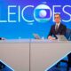 Três apresentadores em estúdio de TV com tela azul exibindo "ELEIÇÕES" e logo da Globo ao fundo