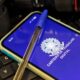 Smartphone exibe app "Carteira de Trabalho Digital" com brasão e caneta azul em teclado