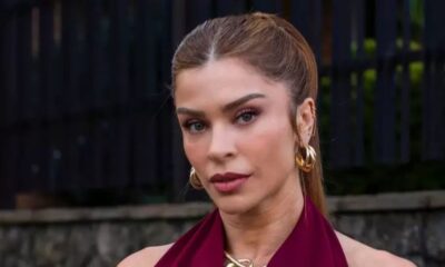 Close-up da atriz Grazi Massafera com cabelo castanho, blusa vinho e brincos dourados