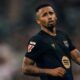 Gabriel Jesus em campo, camisa escura de futebol, barba, tatuagens, boca semiaberta