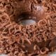 Brigadeirão de chocolate em forma de anel coberto com raspas de chocolate em um prato branco