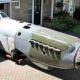 Peter Arnold ao lado da fuselagem de um caça Spitfire dentro de uma garagem