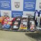 Produtos furtados: chocolates, embutidos, higiene pessoal sobre balcão com logo Segurança Presente