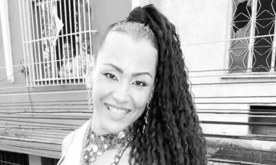 Foto em preto e branco de Julyana Barbosa sorrindo, com cabelo crespo preso
