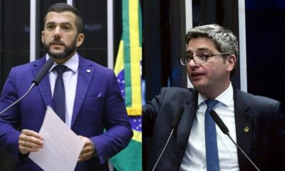 Dois homens em trajes formais discursam, um com barba e o outro de óculos.