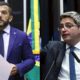 Dois homens em trajes formais discursam, um com barba e o outro de óculos.