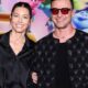 Jessica Biel e Justin Timberlake sorrindo, ele de óculos vermelhos e jaqueta preta acolchoada