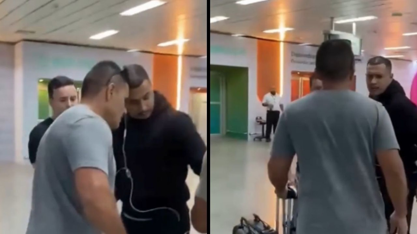 Homem de camiseta cinza escoltado por dois homens em preto no saguão do aeroporto