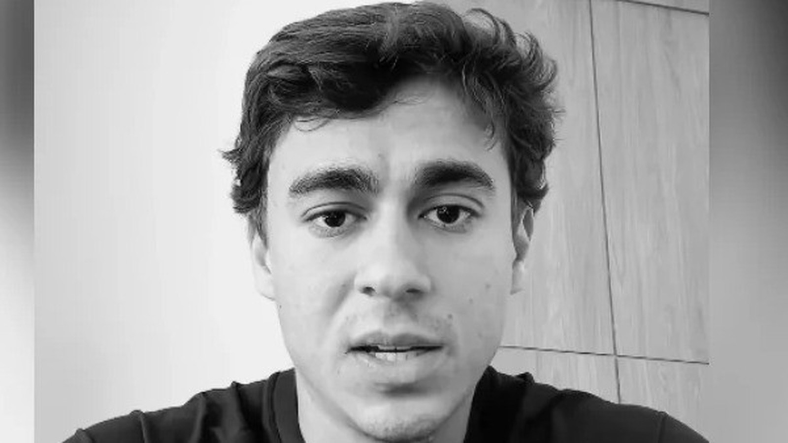 Homem jovem de cabelo escuro, olhar direto, boca entreaberta, em preto e branco