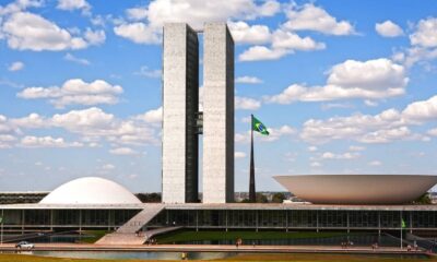 Congresso Nacional do Brasil: duas torres, cúpula, tigela, bandeira brasileira, céu azul
