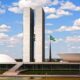 Congresso Nacional do Brasil: duas torres, cúpula, tigela, bandeira brasileira, céu azul