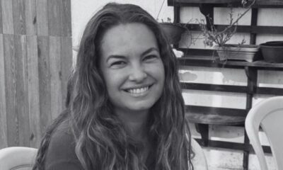 Retrato em preto e branco de Lua Blanco sorrindo, com cabelos longos e ondulados